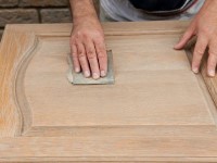 A custom built cabinet door being sanded down for finishing by Cabinet Innovations.