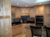 A custom built wet bar made out of birch wood by Cabinet Innovations.